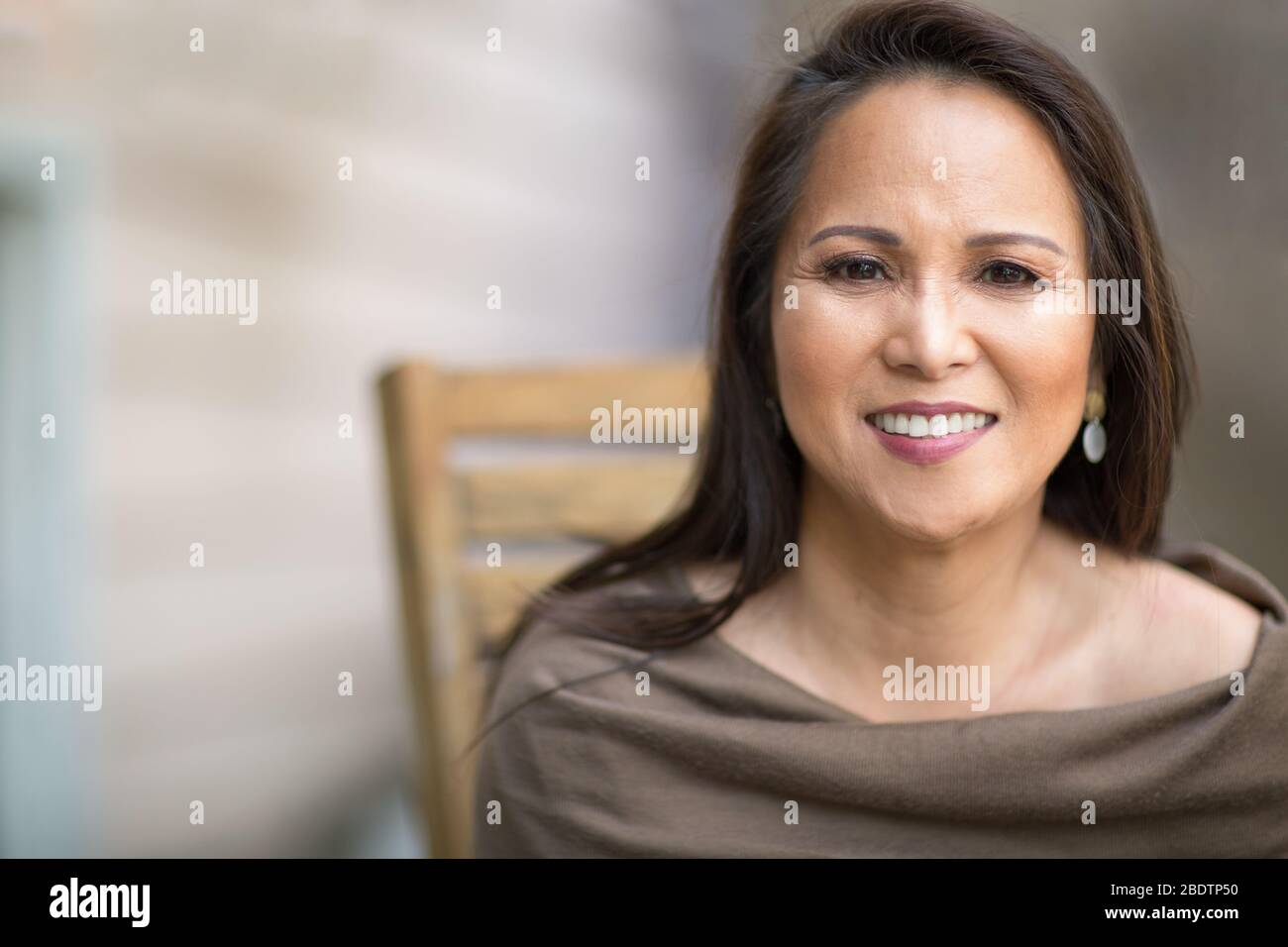Happy mature Asian woman laughing and smiling. Stock Photo