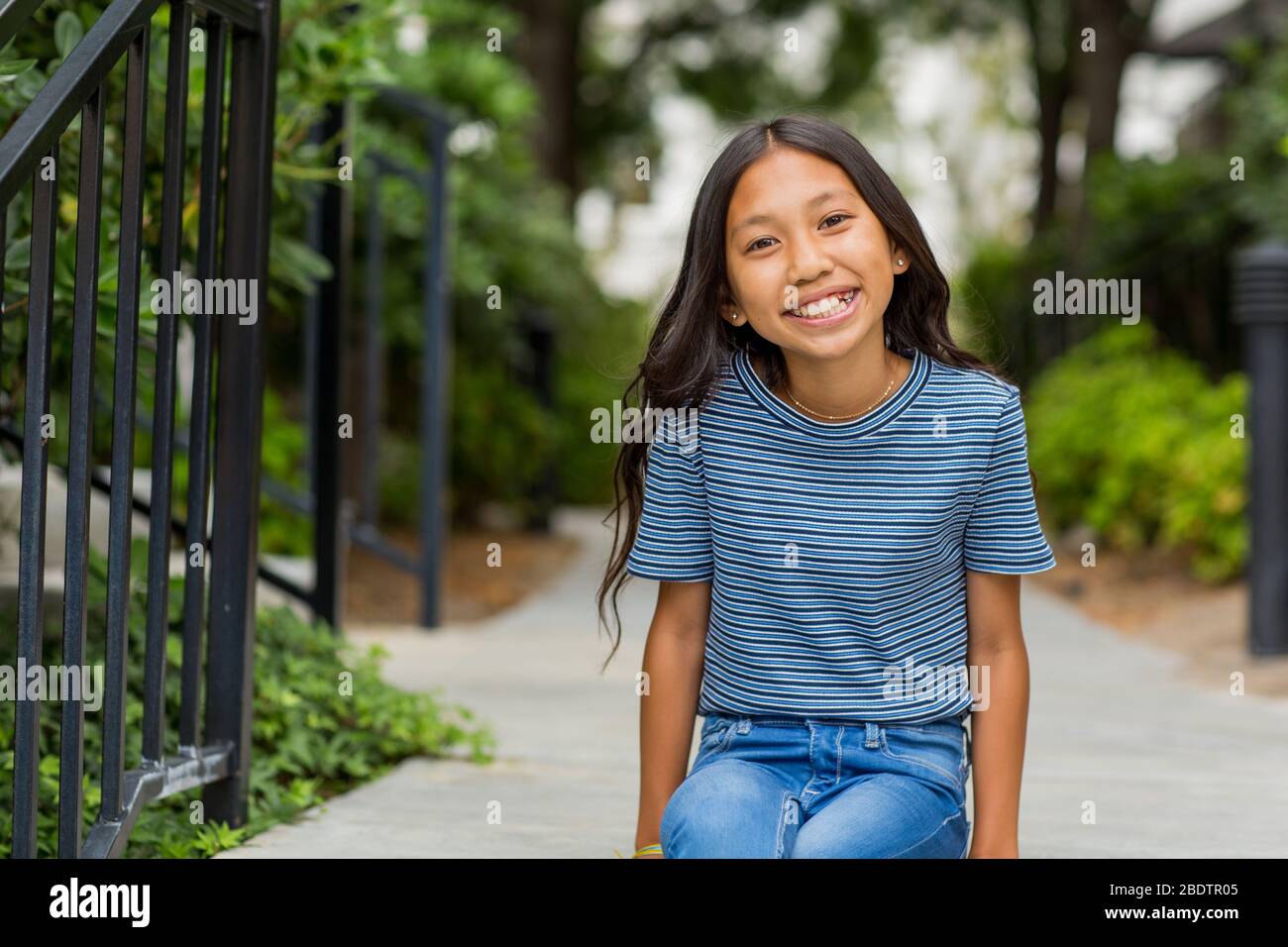 Portrait of a young Asian girl smiling outside. Stock Photo