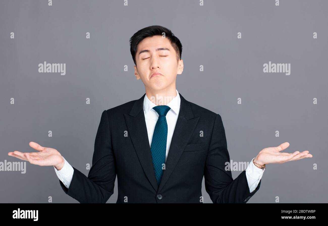 confused young businessman shrugging shoulders and showing helpless  gesture Stock Photo