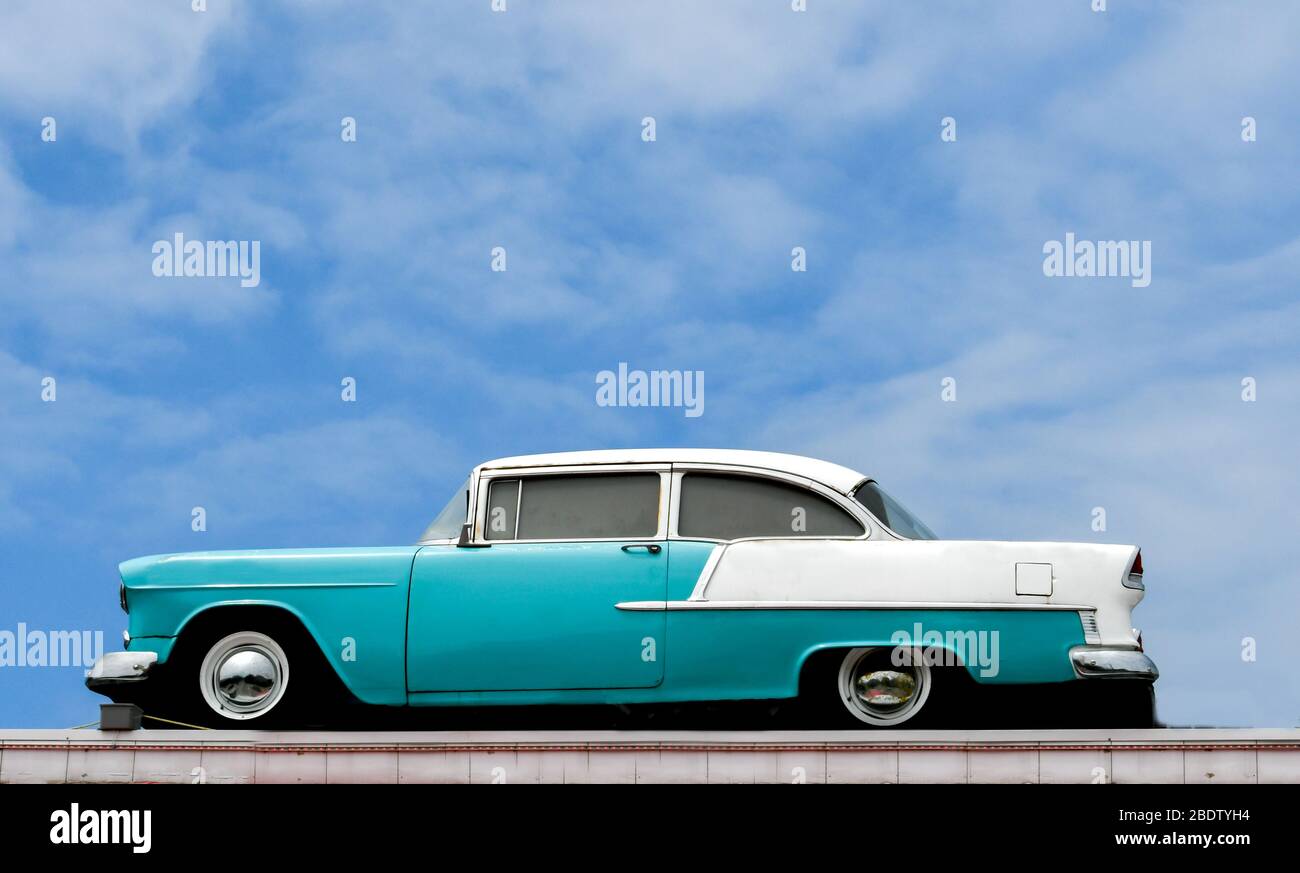 Antique car on display against a cloudy deep blue sky Stock Photo
