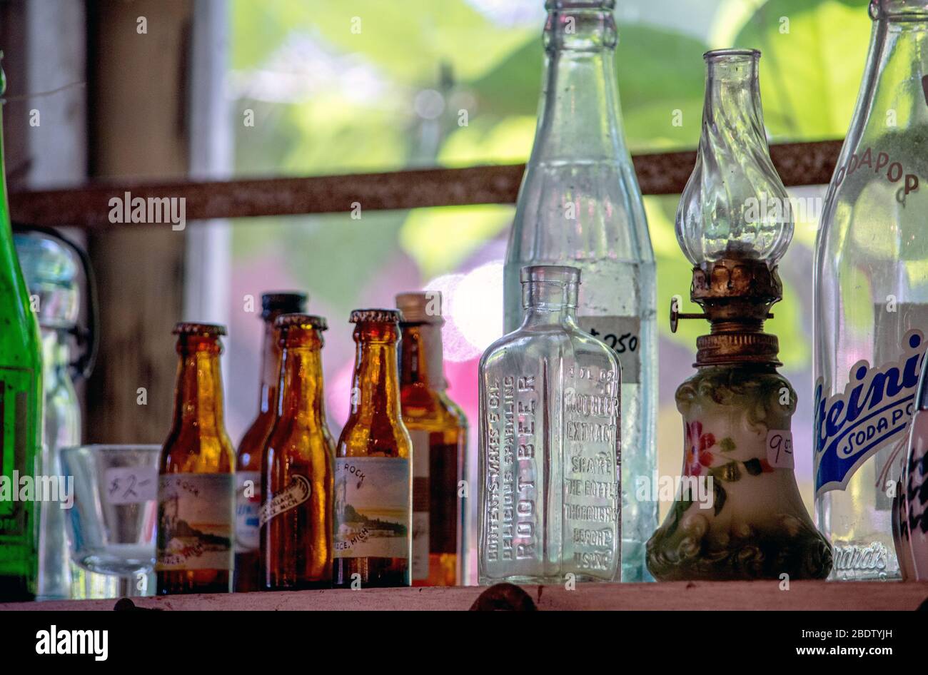 antique lamps and bottles in a window Stock Photo