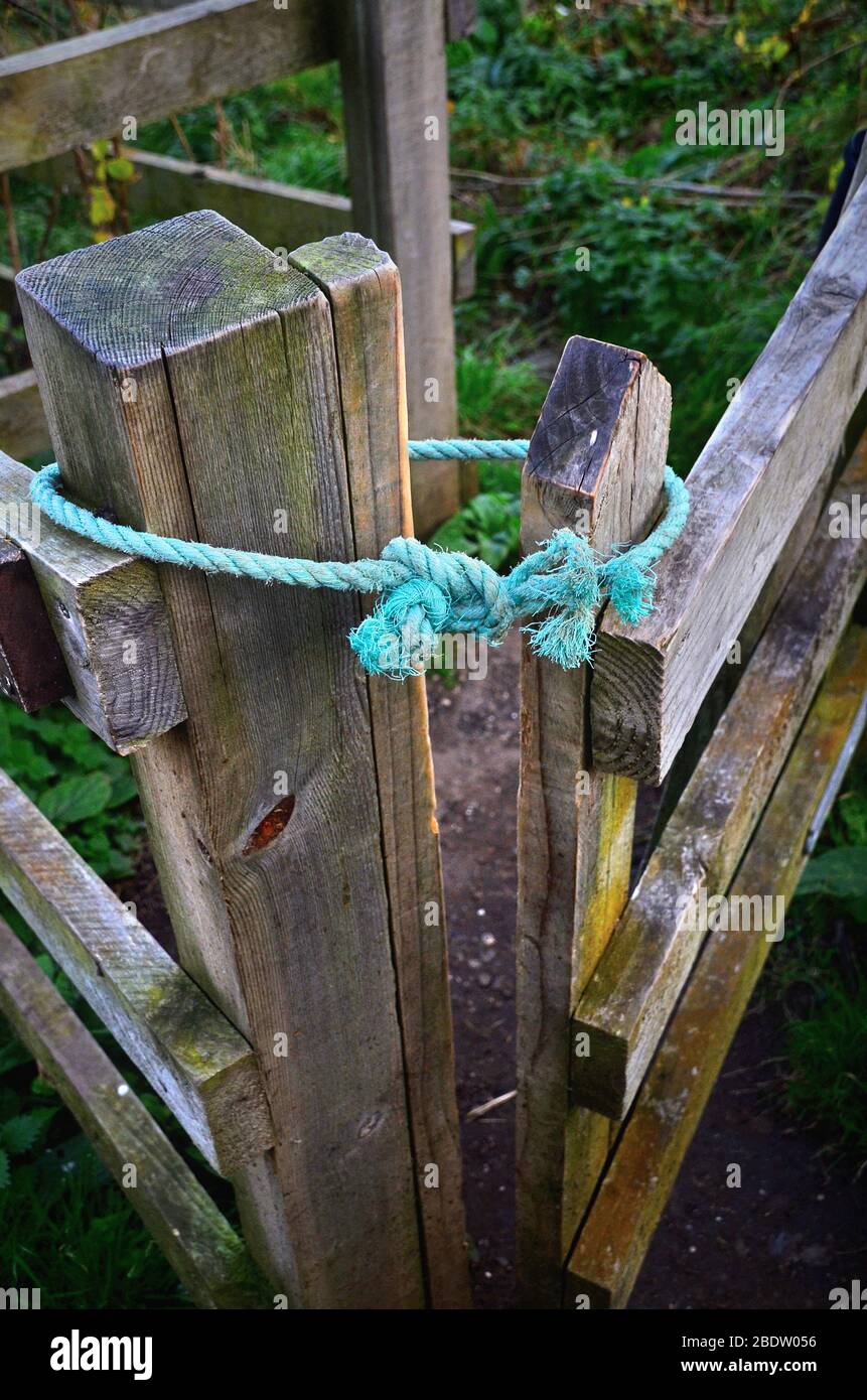 Blue rope latch used to keep kissing gate closed. Stock Photo