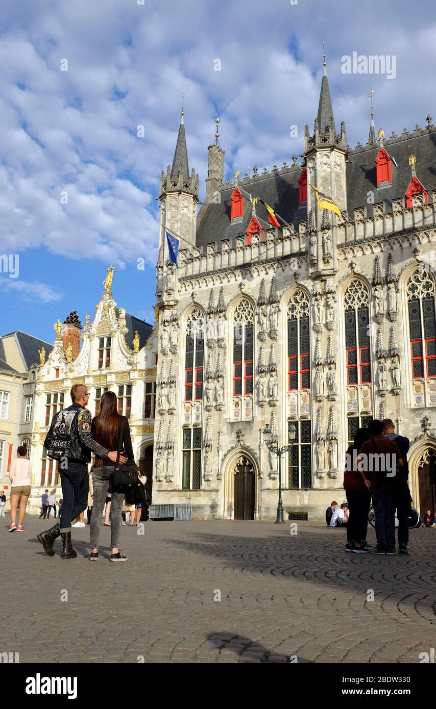Visitors in front of City Hall Stadhuis in Burg Square with a handle bar of a bicycle in foreground.Bruges.West Flanders.Belgium Stock Photo
