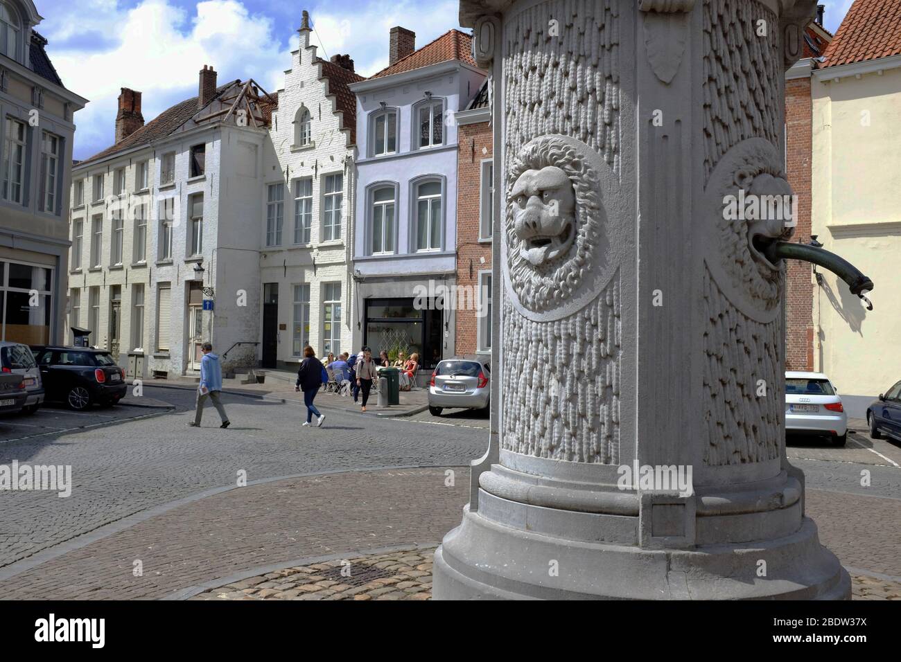 A traditional drinking water fountain with stone carved lion heads in historic center of Bruges.West Flanders. Belgium Stock Photo