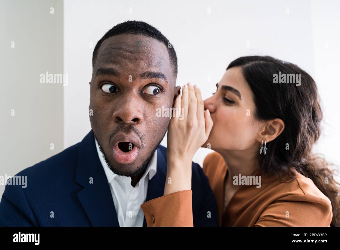 Portrait Of Happy Woman Whispering Secret Or Interesting Gossip To Handsome Man In His Ear Stock Photo