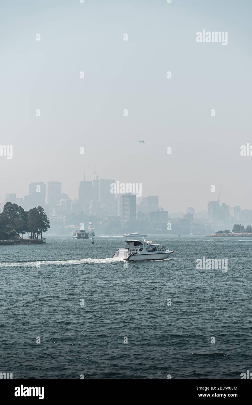 A boat crossing the harbour with the North Sydney skyline visible in the background. Image taken from Pyrmont, NSW. Stock Photo