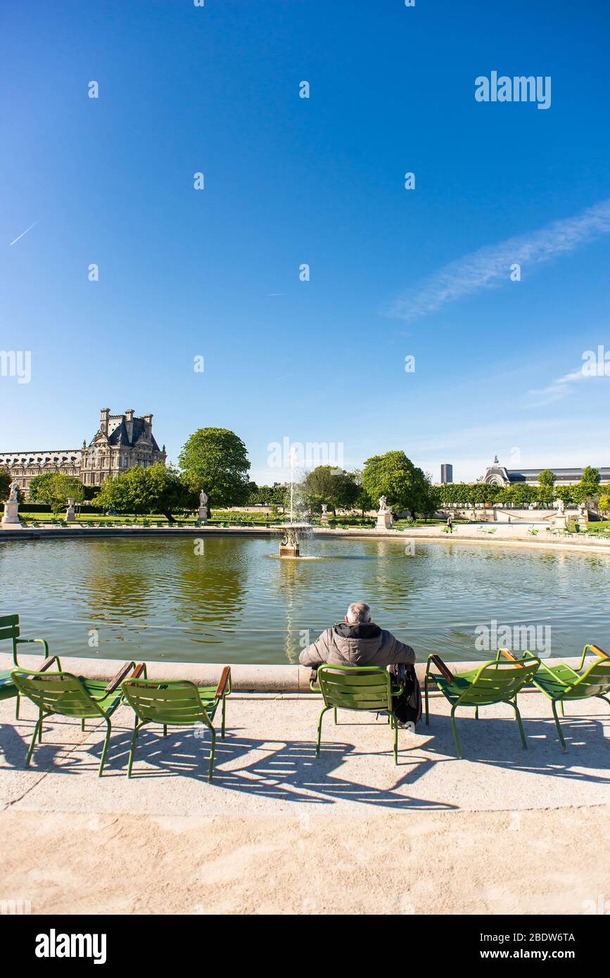 Paris. France - May 15, 2019: Lonely Man Sits and Relaxing on a Chair in Tuileries Garden. Stock Photo