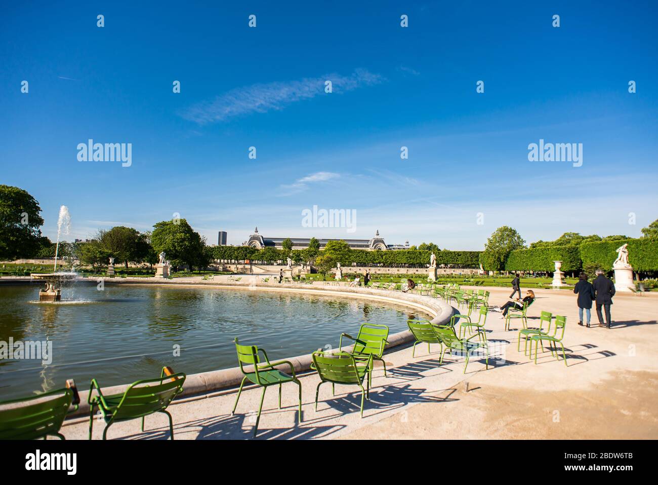 Paris. France - May 15, 2019: People Sits and Relaxing on a Chairs next Fountain in Tuileries Garden. Stock Photo