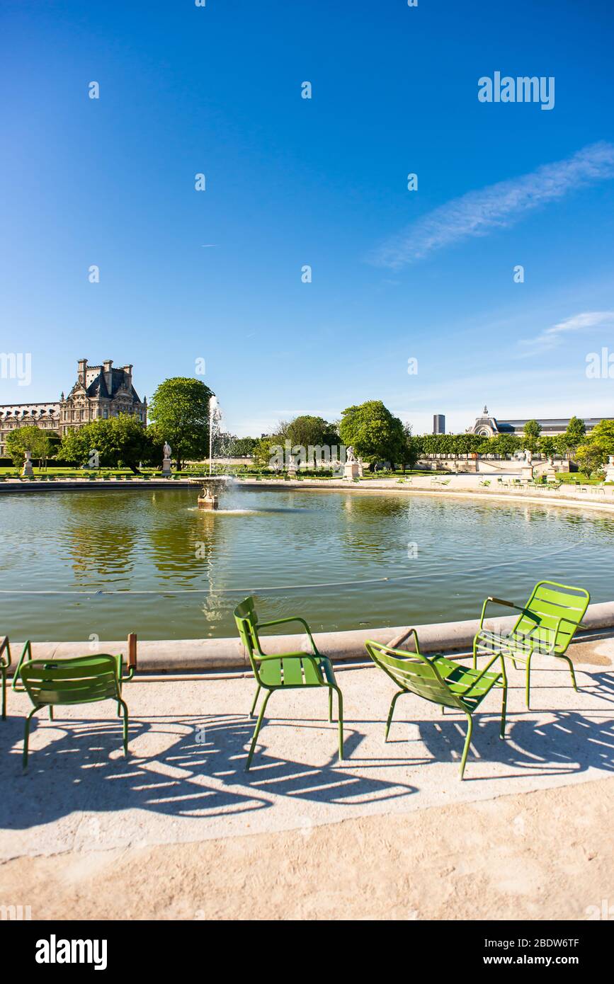 Paris. France - May 15, 2019: Green Chairs next Fountain in Tuileries Garden. Stock Photo