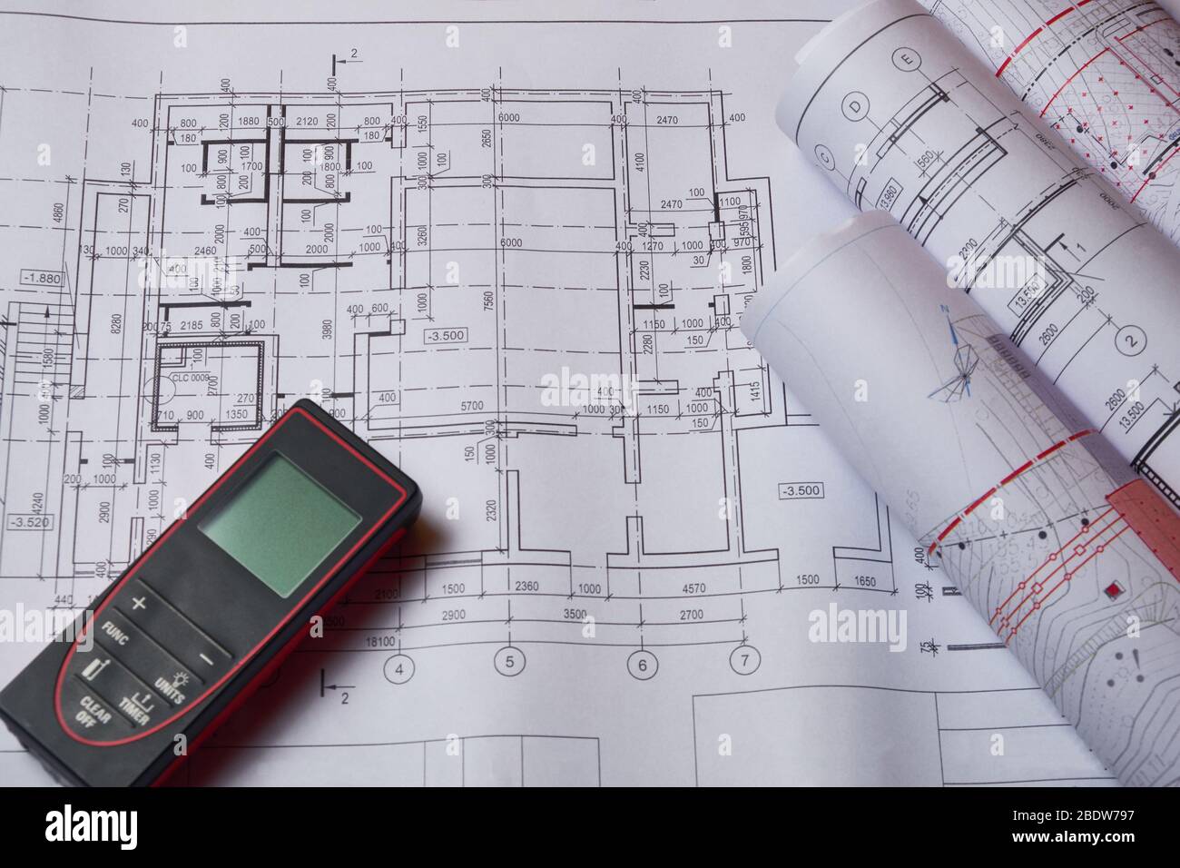 Laser meter and drawings at engineer workplace. Stock Photo