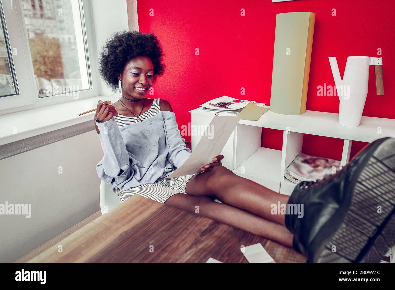 Cheerful young designer working at her project Stock Photo