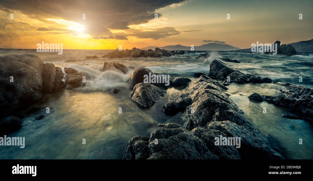 Beautiful seascape with rocks and waves at sunset Stock Photo - Alamy