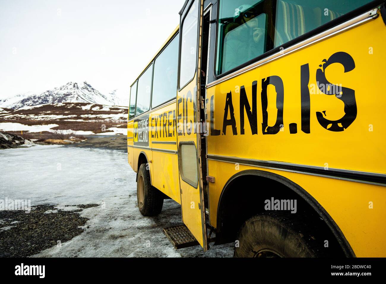 Tourists wearing winter clothes get off the bus for a hike on Svinafellsjokull glacier an outlet glacier of Vatnajokull, South Iceland Stock Photo