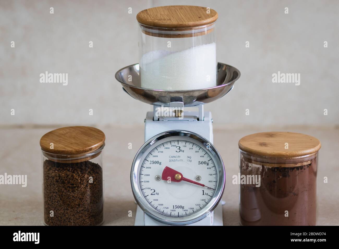 vintage analog kitchen weight, next to glass jars filled with cocoa coffee and sugar Stock Photo