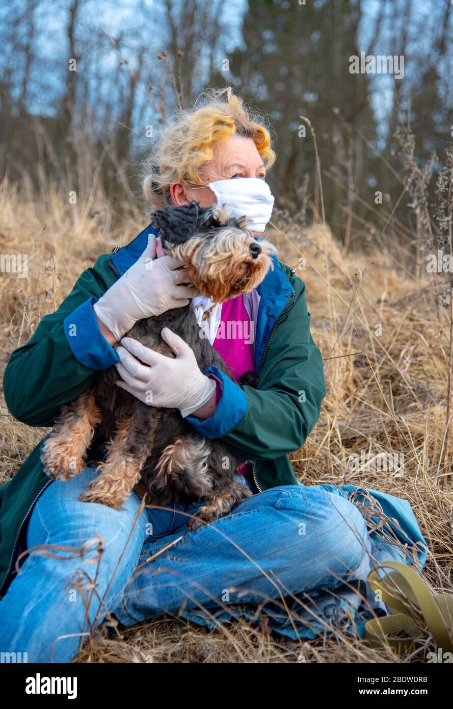 An elderly woman in a protective medical mask and rubber gloves on a