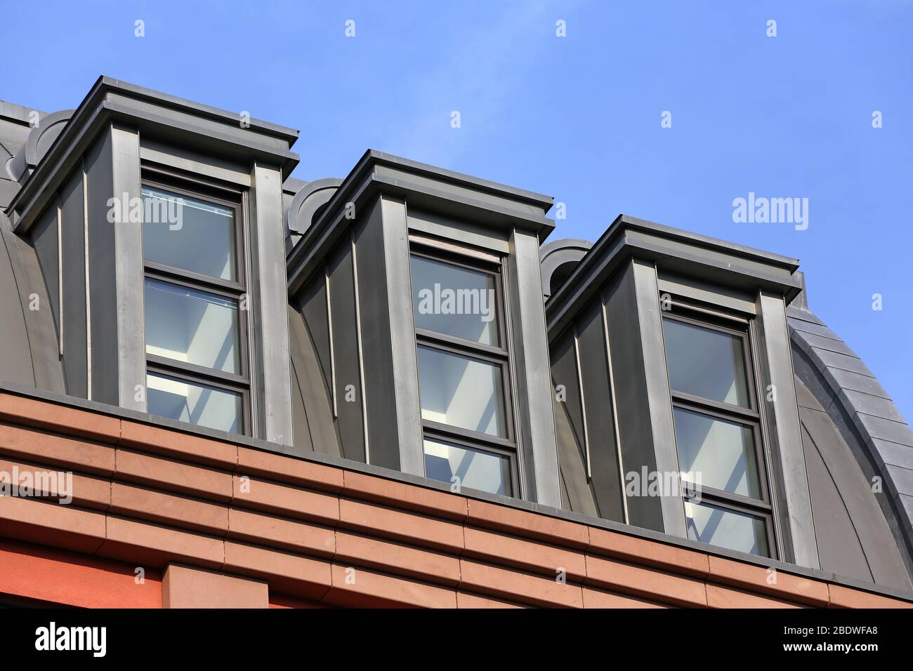 three high dormers on rooftop of modern building Stock Photo