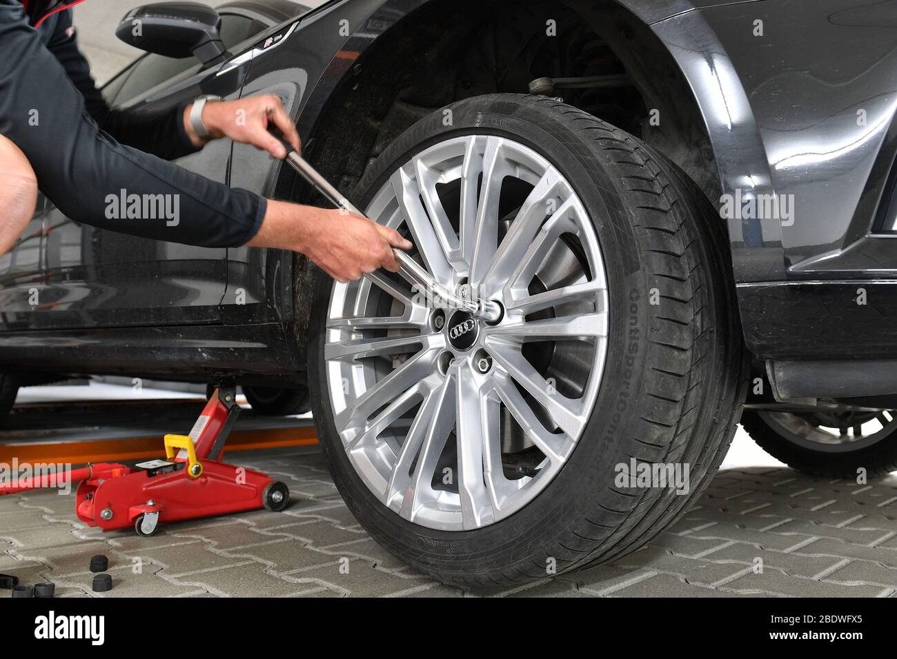 grafing deutschland 10th apr 2020 winter on summer tires corona crisis makes changing tires difficult change of wheels in the garage at home do it yourself the jack is attached the wheel bolts are loosened with a wheel wrench usage worldwide credit dpaalamy live news 2BDWFX5