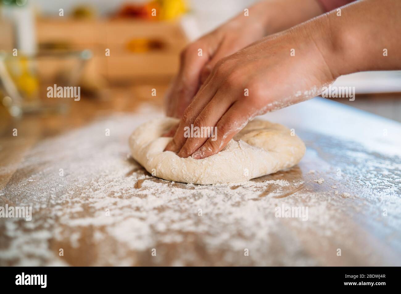 Woman kneading the dough to make a pizza in her home kitchen Stock ...