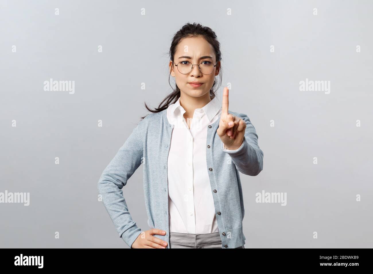 People, emotions and lifestyle concept. Strict, serious-looking asian woman, teacher scolding student talking during classes or cheating on exam Stock Photo