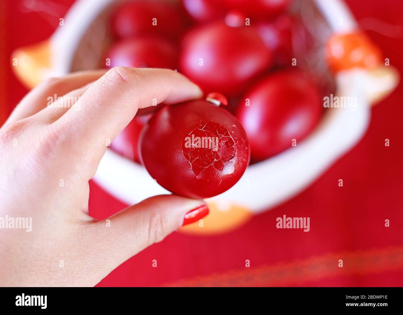 hand holding a cracked red Easter egg Orthodox greek tradition of
