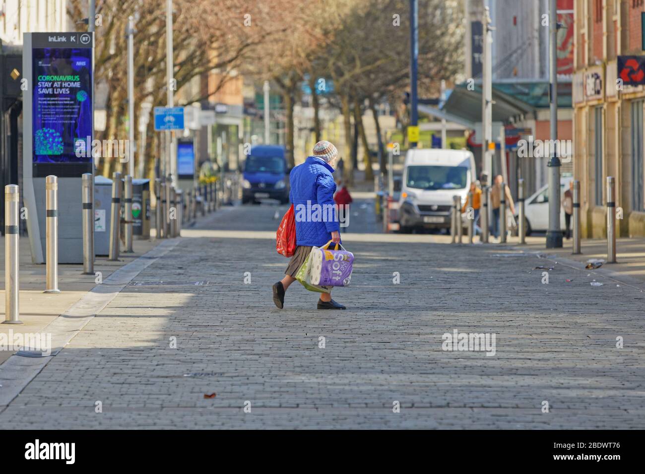 Pictured: An elderly woman with shopping in Oxford Street,  Swansea, Wales, UK. Thursday 26 March 2020 Re: Covid-19 Coronavirus pandemic, UK. Stock Photo
