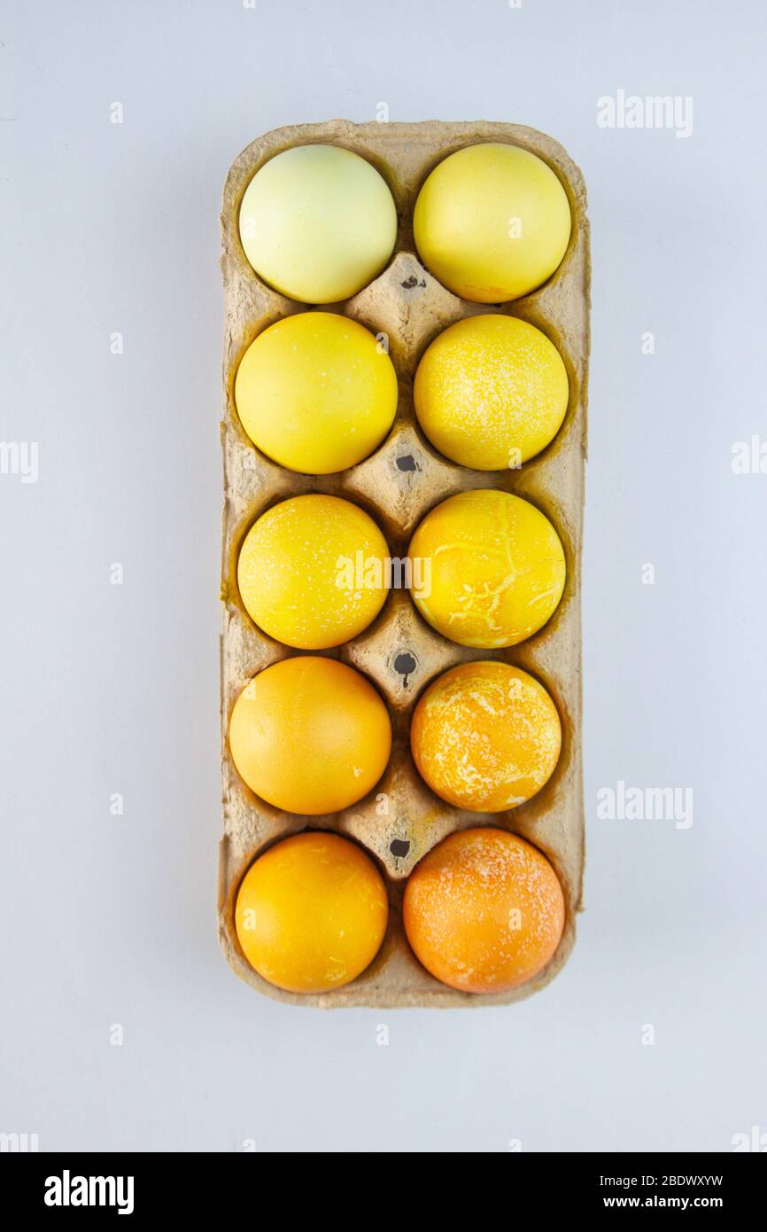 Different shades of yellow eggs in a paper container. Easter eggs. Stock Photo