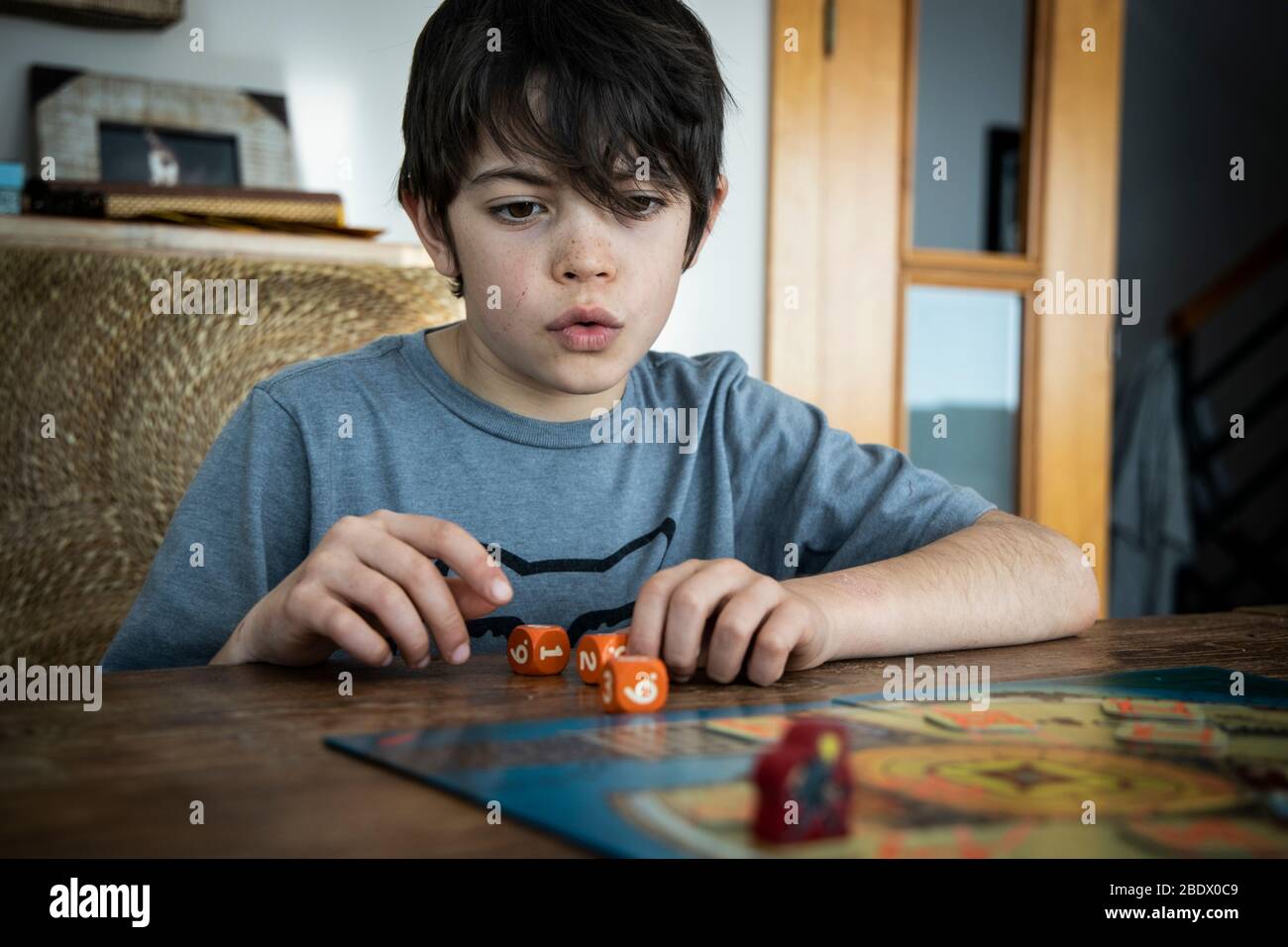 Boy playing board game during Covid19 confinement in Catalonia, Spain Stock Photo