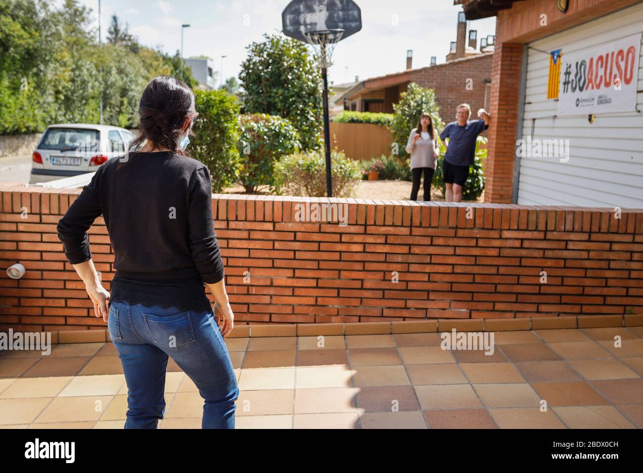 Woman talking to neighbours from a distance during Covid19 lockdown in Catalonia, Spain Stock Photo