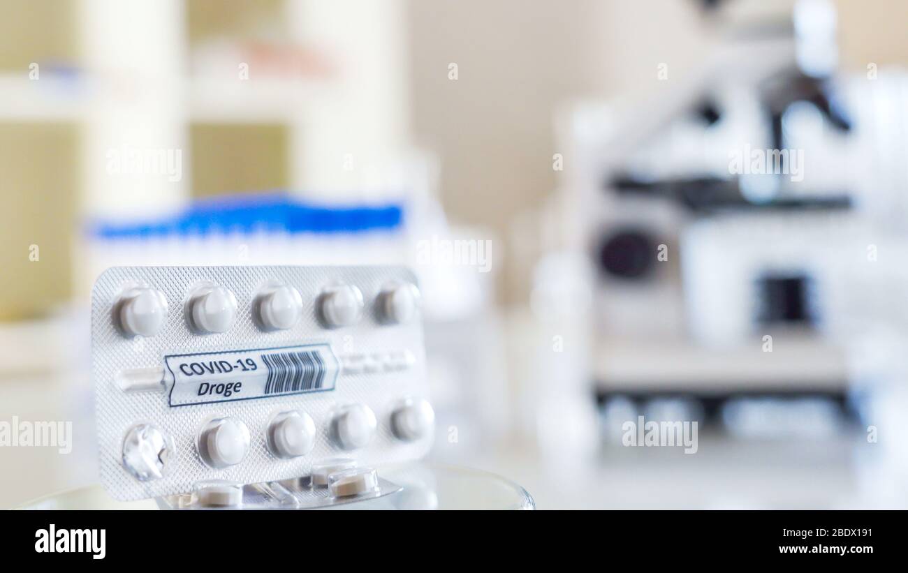 A coronavirus medicine tablet with the drug Covid-19 Droge written in German on it found on the top of the table inside the laboratory Stock Photo