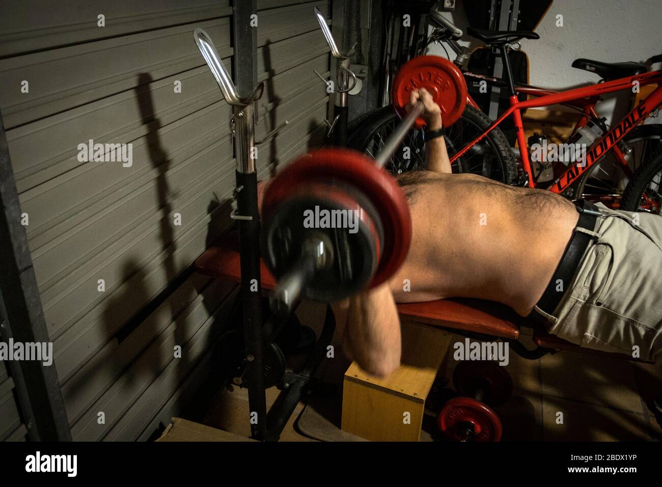 Man doing weights in garage of home during Covid19 confinement in Girona, Catalonia, Spain Stock Photo