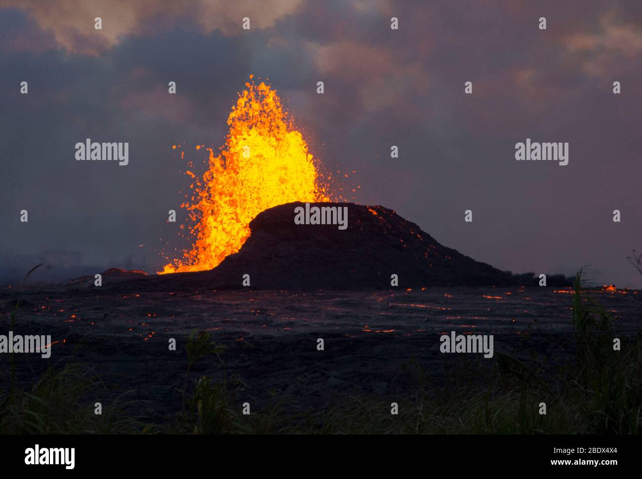 Lava erupts from a fissure in the Leilani Estates neighborhood at dusk, May 23, 2018. Stock Photo