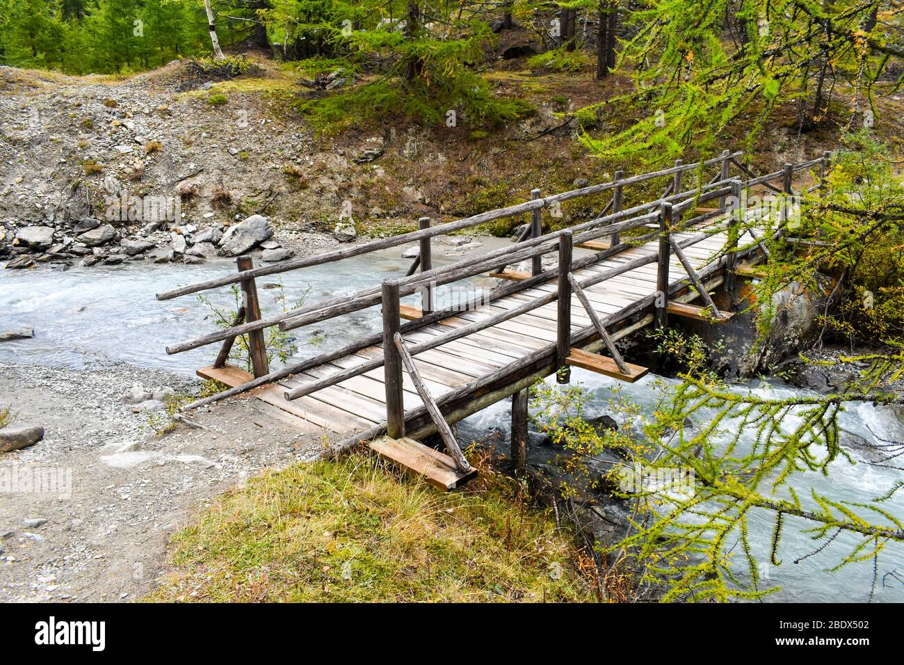Wooden foot bridge over creek. Stock Photo