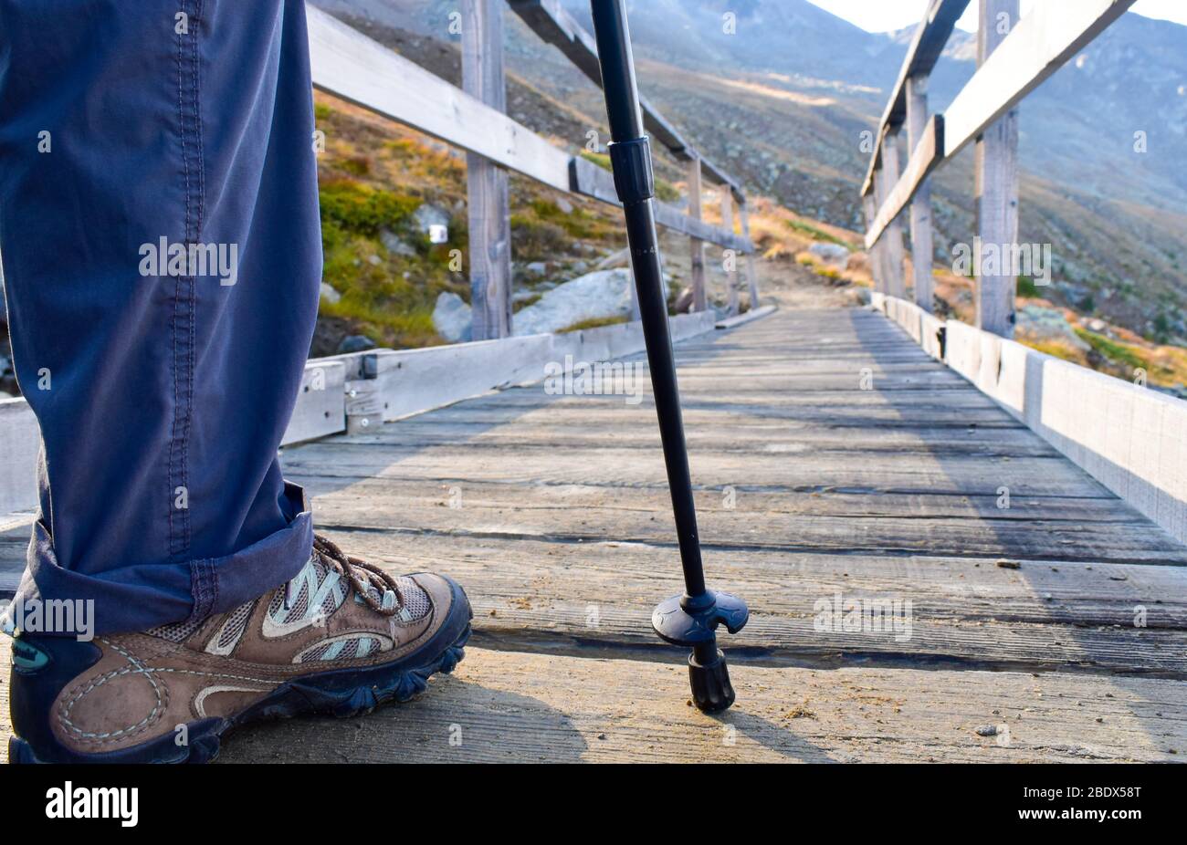 Hikers foot and trekking pole on the bridge Stock Photo Alamy
