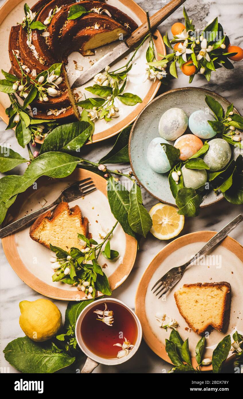 Easter table setting with colorful eggs and citrus cake Stock Photo