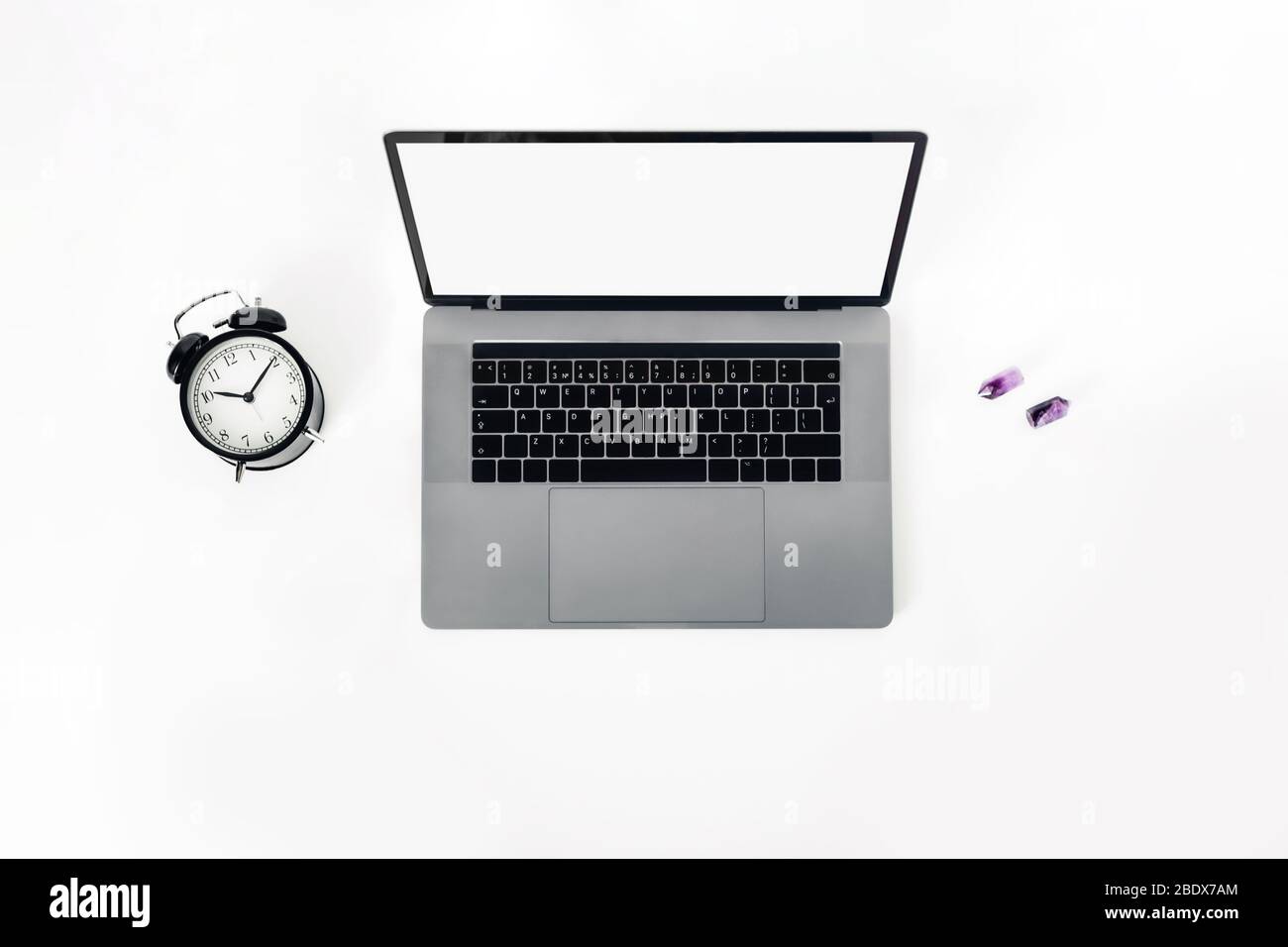 A black-and-white workplace with a laptop, alarm clock. Stock Photo