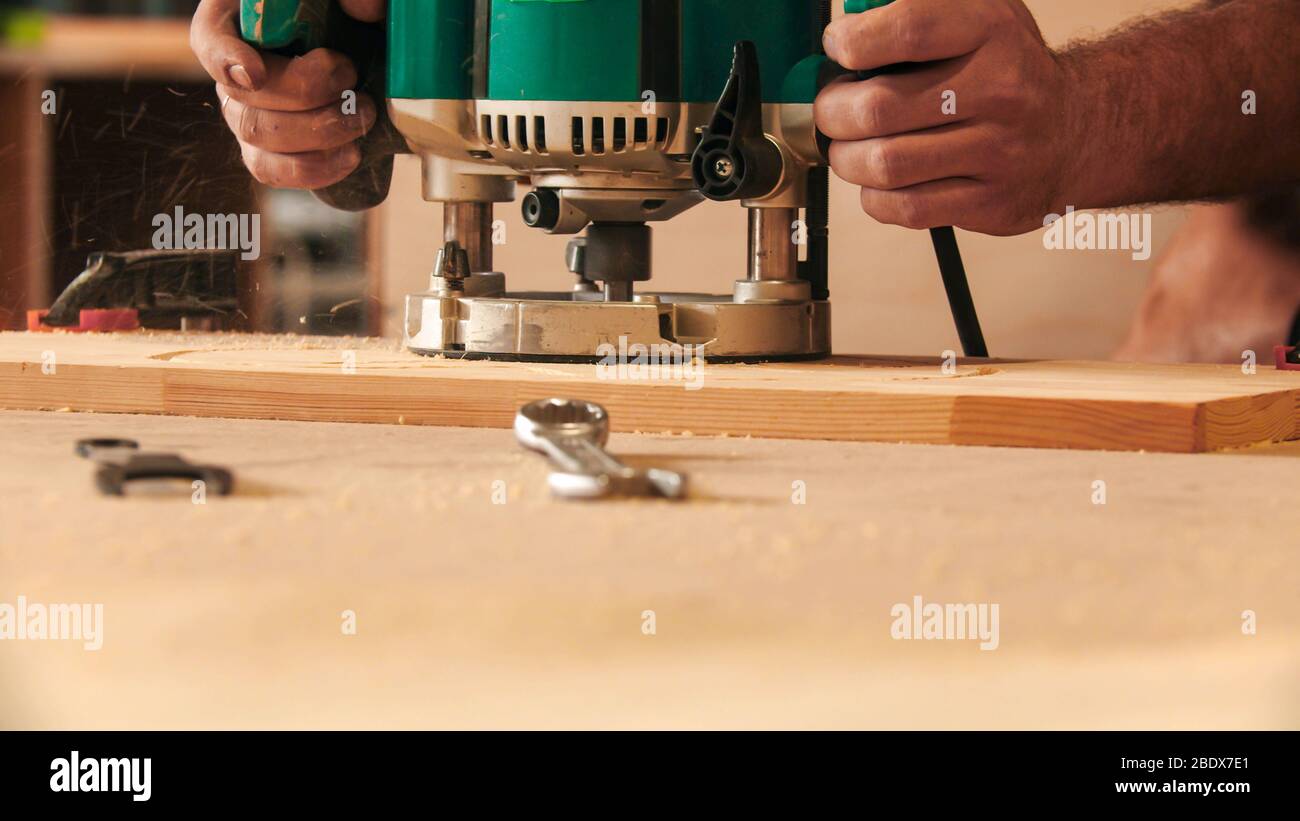 Carpentry industry - worker cutting out the patterns out of the wooden ...
