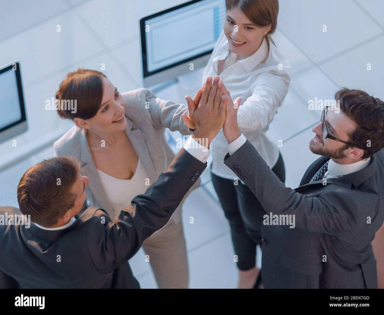 successful business team giving each other a high-five, standing Stock ...
