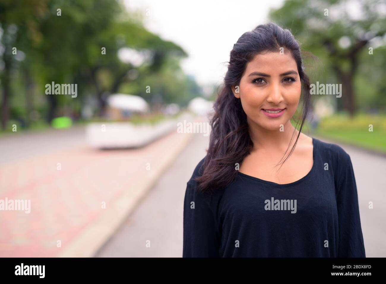 Happy young beautiful Persian woman relaxing at the park Stock Photo