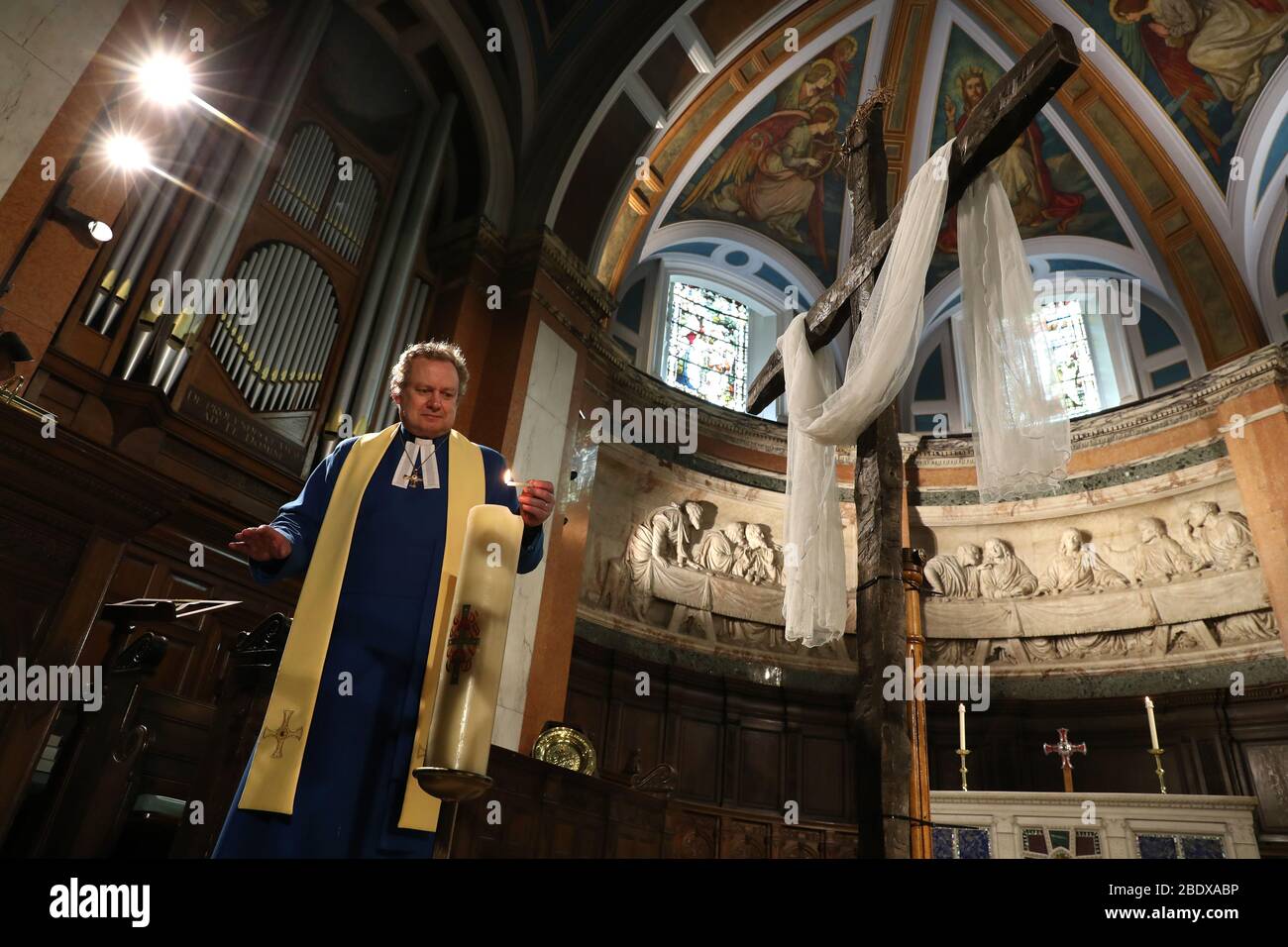 Embargoed to 0001 Saturday April 11 The Rev Peter Sutton lights the Easter candle as he records the Easter Sunday sermon in the Main Sanctuary at the Parish Church of St Cuthbert in Edinburgh, the church has been streaming sermons as the UK continues in lockdown to help curb the spread of the coronavirus. Stock Photo