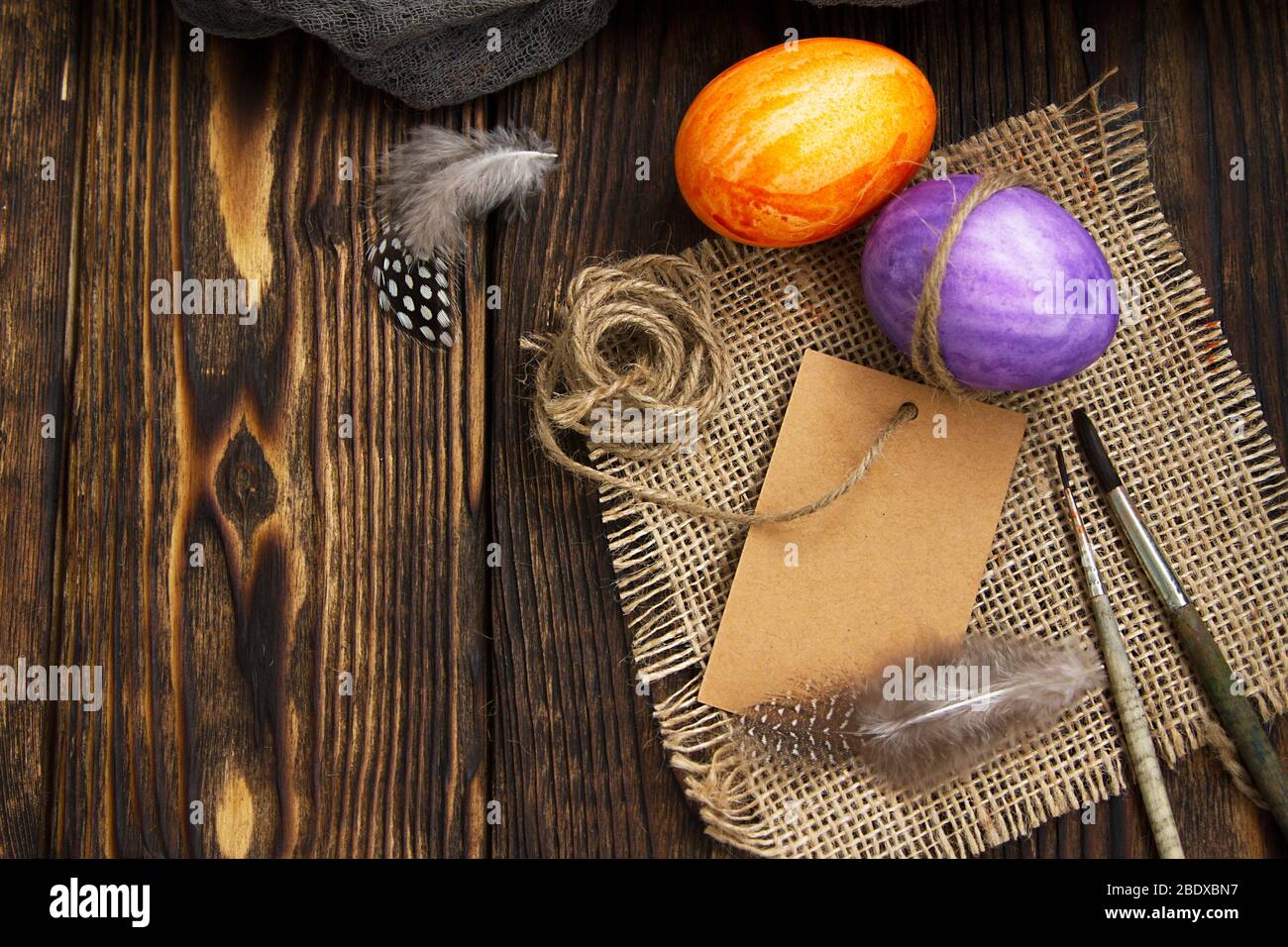 painted two eggs for Easter on a wooden table next to brushes Stock Photo