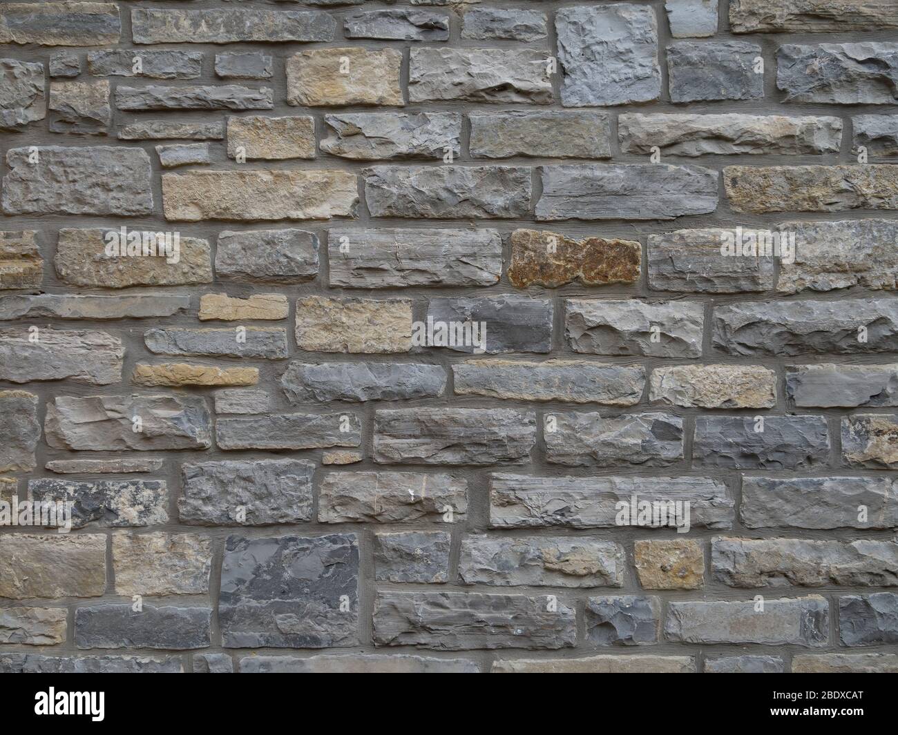 Traditional local stone house wall in Street, Somerset, England. Maybe blue lias. Old. Stock Photo