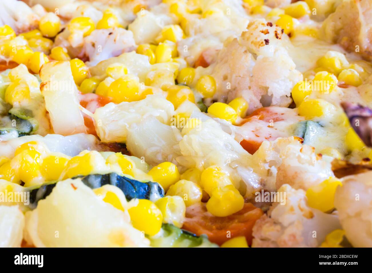 Close-up of homemade vegetarian veggie pizza with cheese, pineapple, corn, vegetables, zucchini, cauliflower Stock Photo