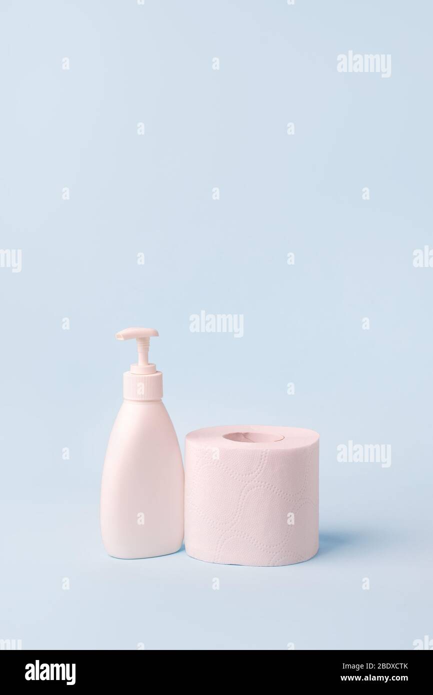 Set of toilet paper roll and liquid soap or sanitizer on blue. The ...