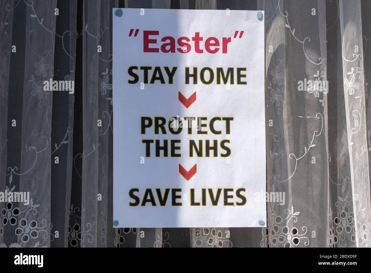 Southend on Sea, Essex, UK. 10th Apr, 2020. On the first day of the Easter weekend during the COVID-19 Coronavirus lockdown period people are making use of Southend on Sea’s seafront to enjoy the sunny and warm weather. A sign in a house window states Easter, stay home, protect the nhs, save lives Stock Photo