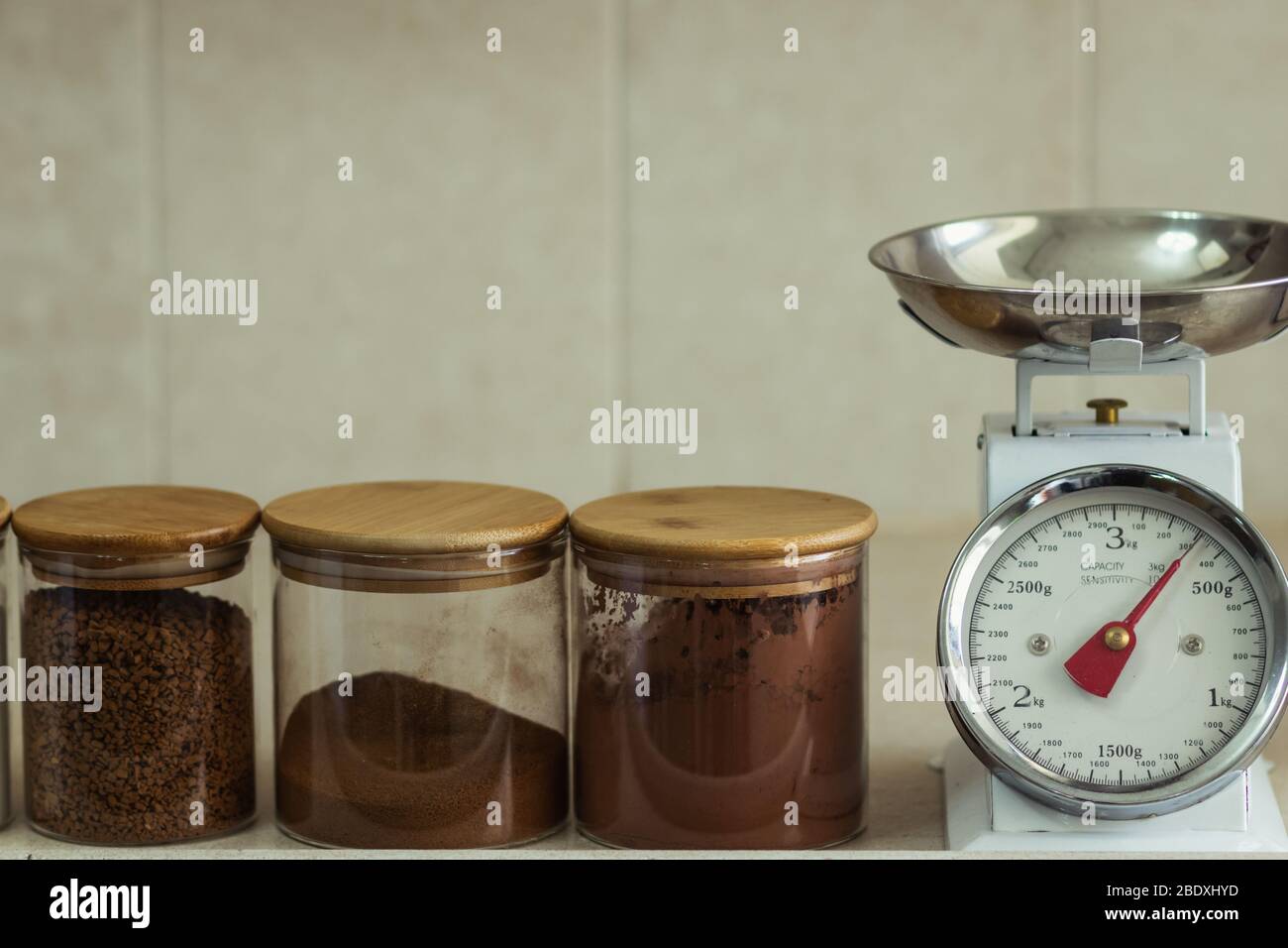 vintage analog kitchen weight, next to glass jars filled with cocoa coffee and sugar Stock Photo