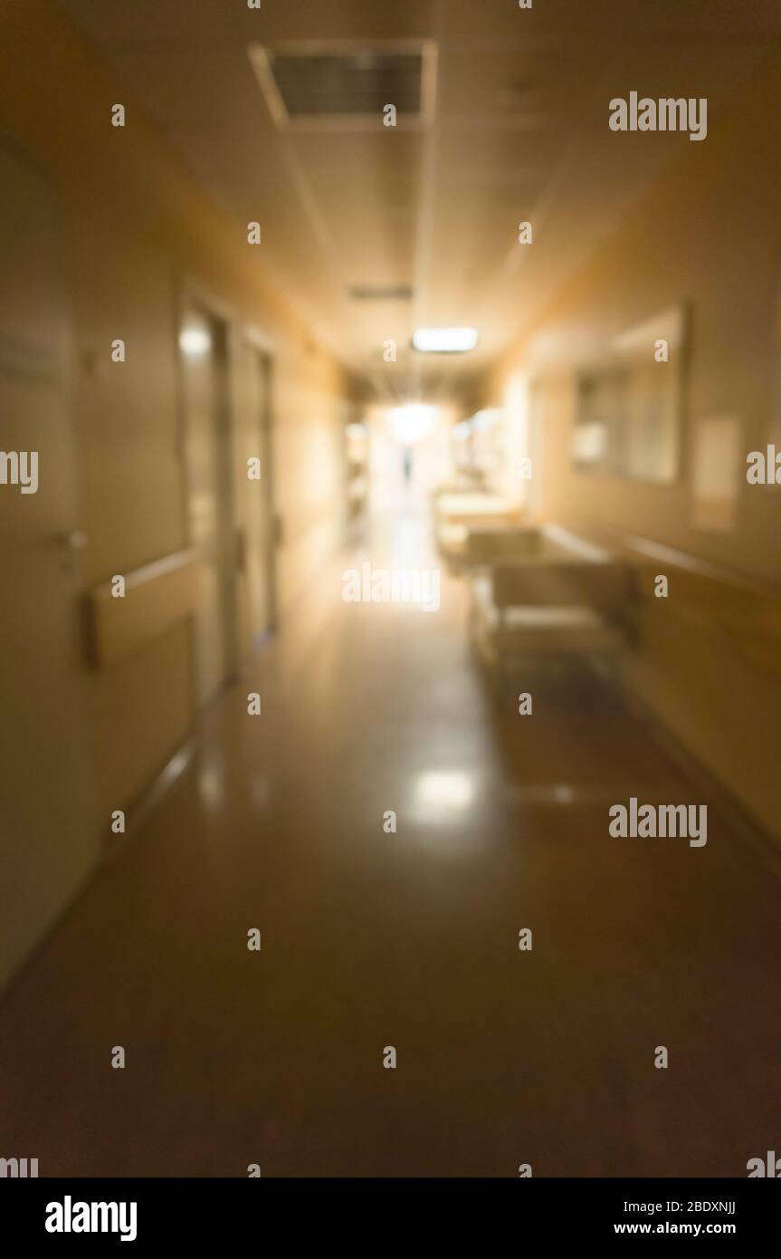 Bright light at the end of the dark corridor in the hospital. The image is out of focus. The concept of the path to recovery. Stock Photo