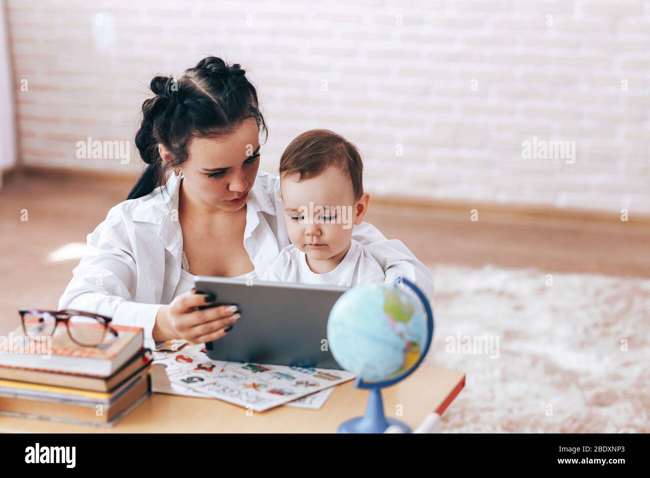 Happy mother and son watch educational videos, mother and son talk on video calls, the teacher deals with the child, educational games, quarantine Stock Photo