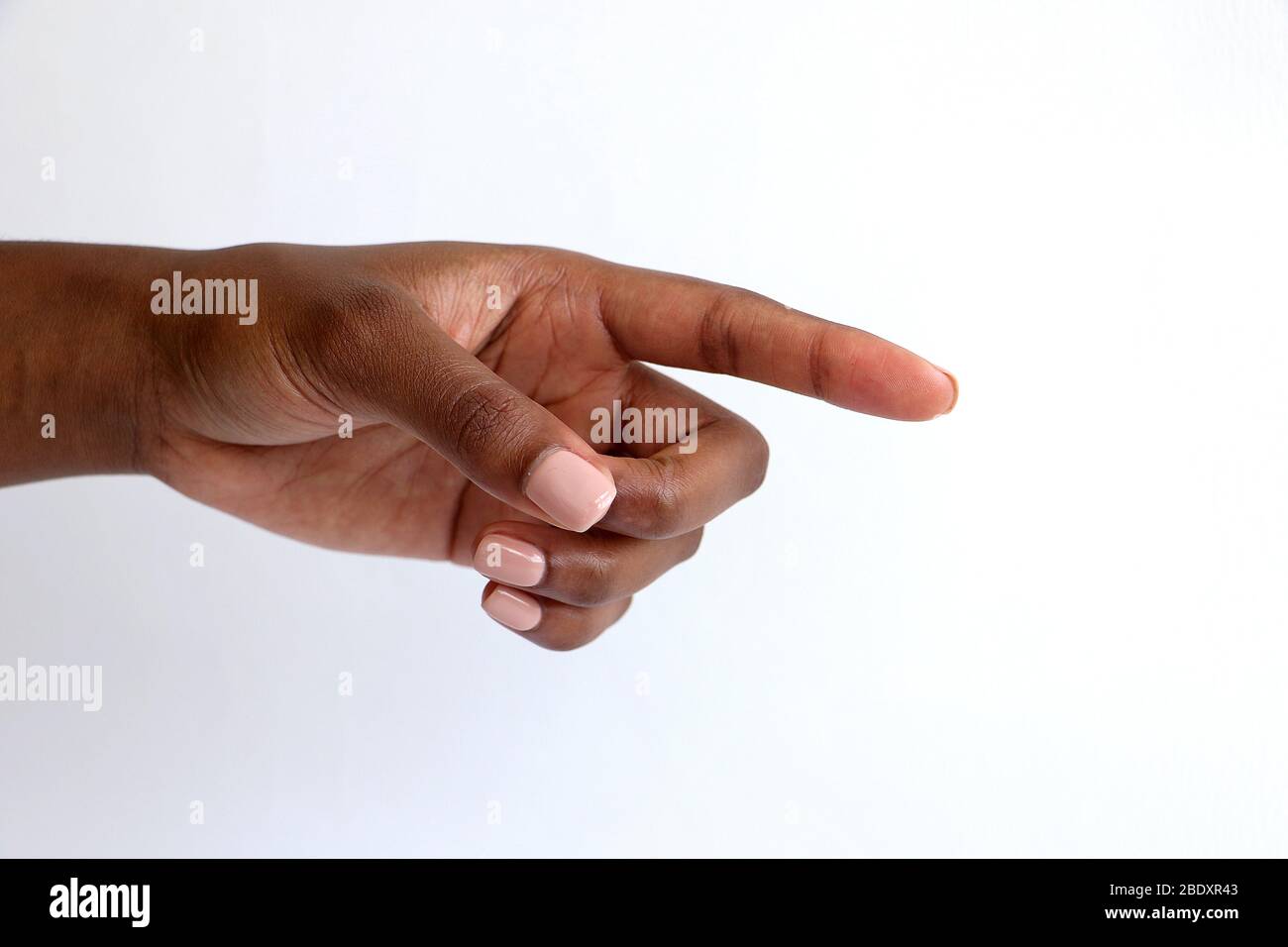Isolated female black African Indian manicured hand pointing gesture against a white background Stock Photo