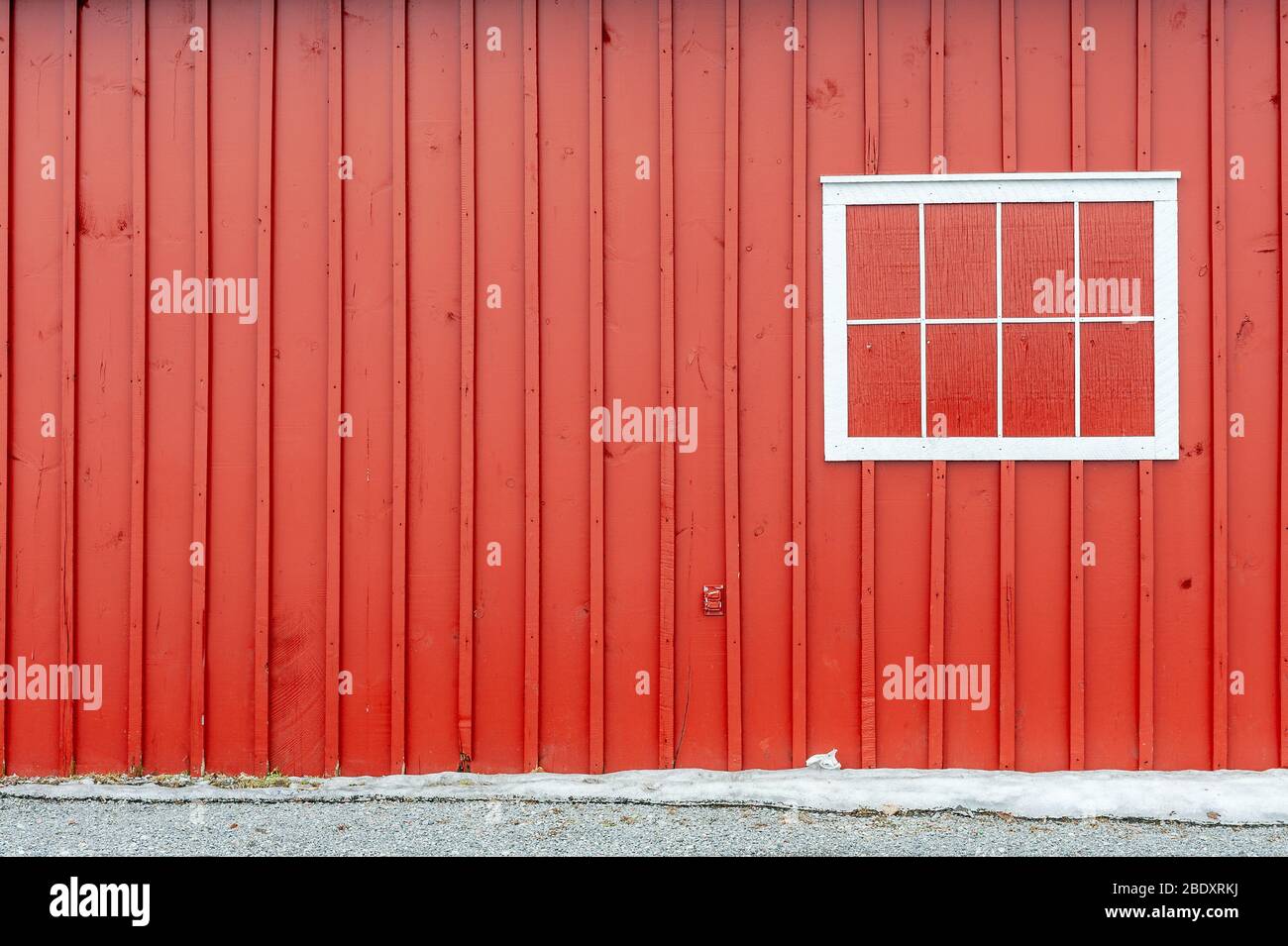 Shuttered window on red wall Stock Photo