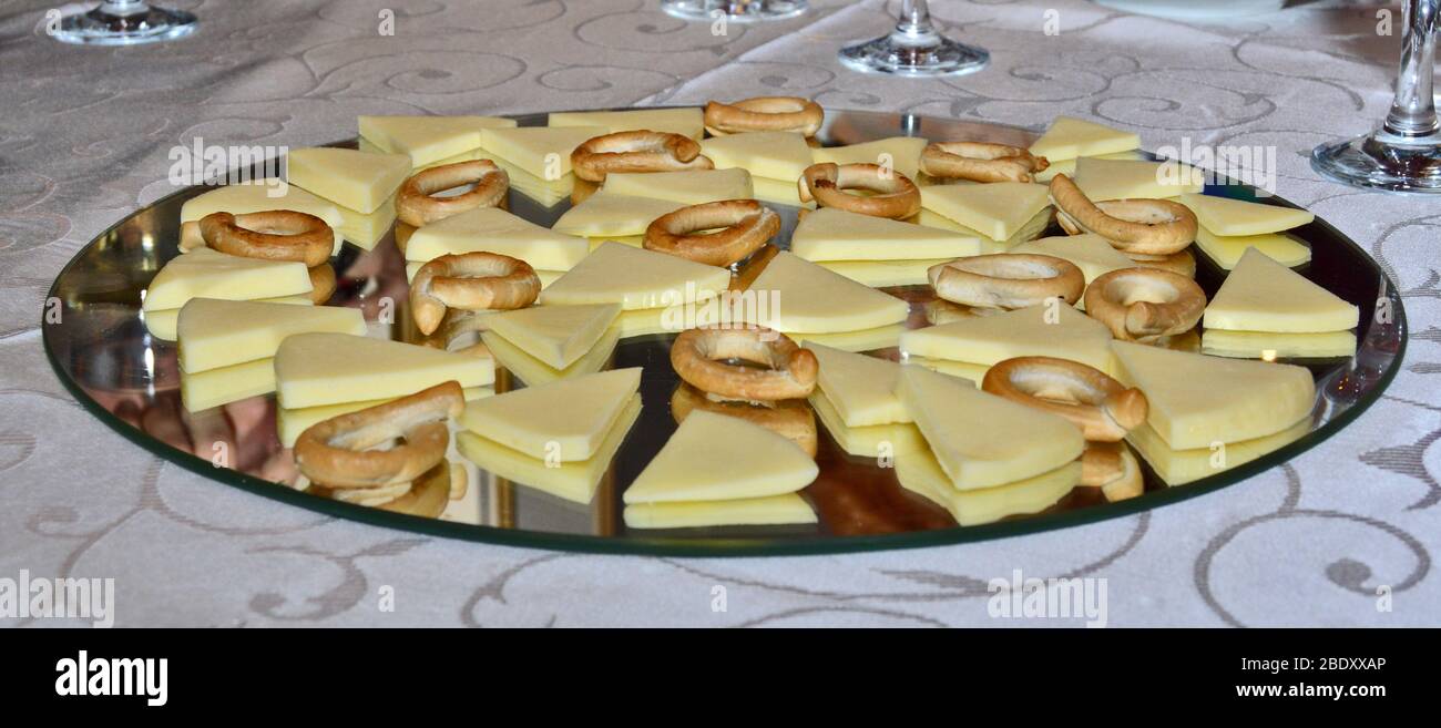 Tasty looking cheese arrangement on mirror platter, tasting cheeses paired with tiny pretzels on nice plating, organic and fresh Stock Photo